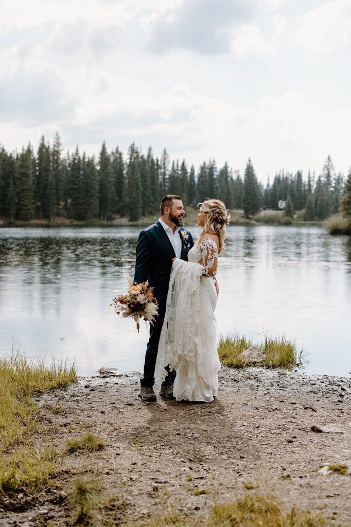Bride and Groom pose and look at each other near a pond during their Colorado Elopement ceremony. 