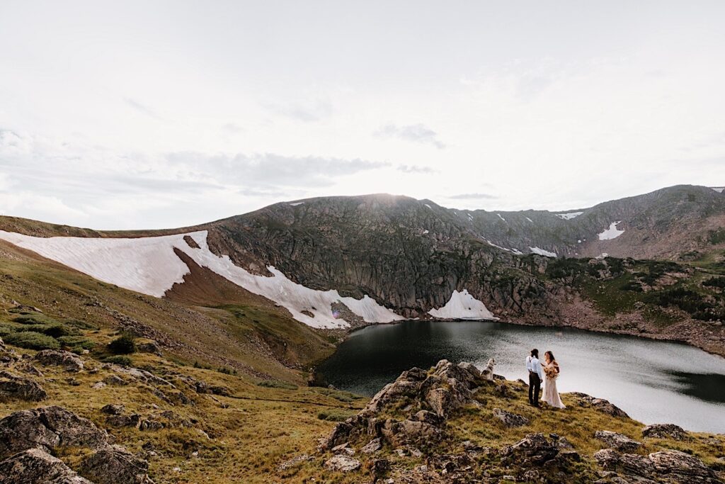 Bride and Groom read their vows on a cliff overlooking a beautiful Colorado Mountain cove during their intimate elopement. 